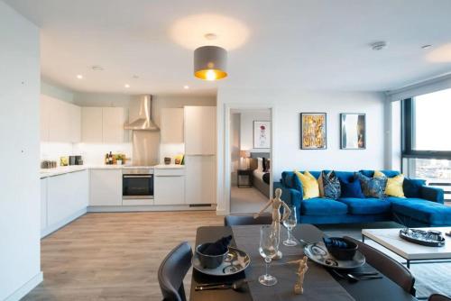 a living room with a blue couch and a table at Duet Manchester in Manchester