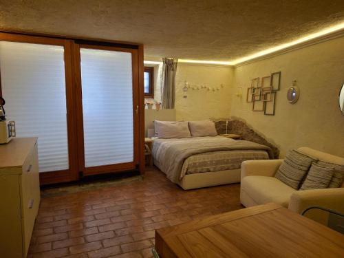 a bedroom with a bed and a couch and a living room at Tavernetta vicino Lago Trasimeno in Magione