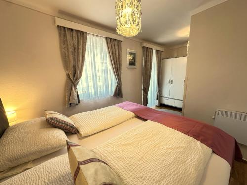 a bedroom with a large bed and a chandelier at Gästehaus Gertrude in Velden am Wörthersee