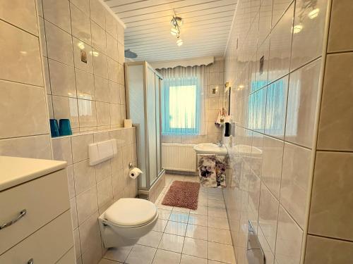 a white bathroom with a toilet and a sink at Gästehaus Gertrude in Velden am Wörthersee