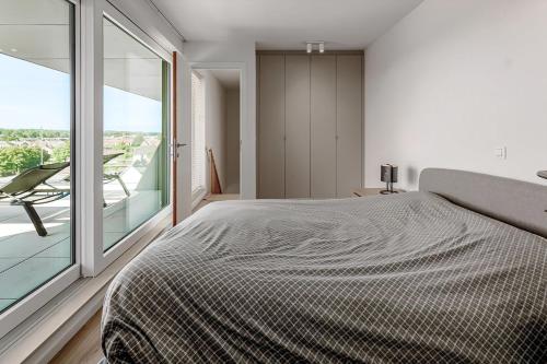a bedroom with a large bed and a large window at Villa Zephir O3O5G 221 in Nieuwpoort
