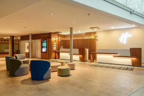 a lobby of a hotel with chairs and tables at Holiday Inn Berlin Airport - Conference Centre by IHG in Schönefeld