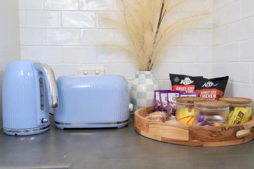a counter with a toaster and a tray of food at Leo's Beach Haven in Batehaven