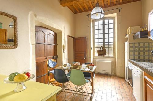 une cuisine avec une table et des chaises dans une pièce dans l'établissement La Petite Provence de Camille, à Saint-Rémy-de-Provence