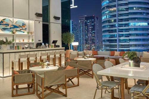 a restaurant with tables and chairs and a city skyline at Vida Yacht Club # Up-scale 2BHK # Marina,Sea & Ain View in Dubai