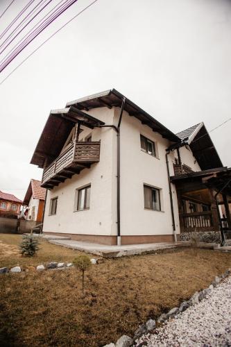 a large white house with a roof at Boierița Home Stay in Fundu Moldovei