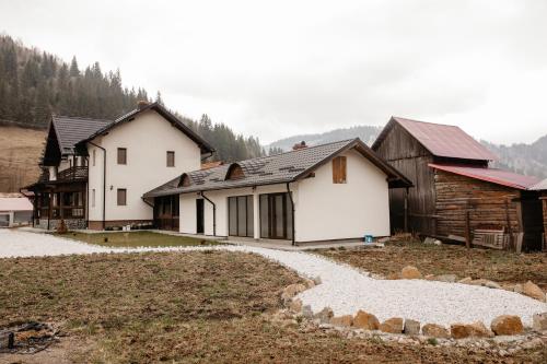 a group of houses in a field with trees at Boierița Home Stay in Fundu Moldovei