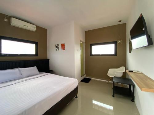 Un dormitorio con una cama, un escritorio y un televisor. en Sahasi Stay, en Kalibata 1