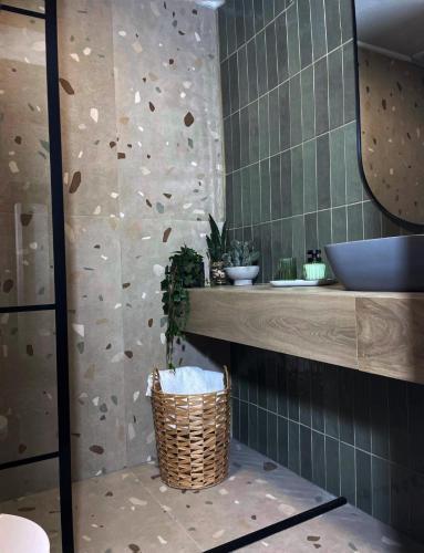 a bathroom with a rock wall and a wicker basket at Vila Aldor in Bran