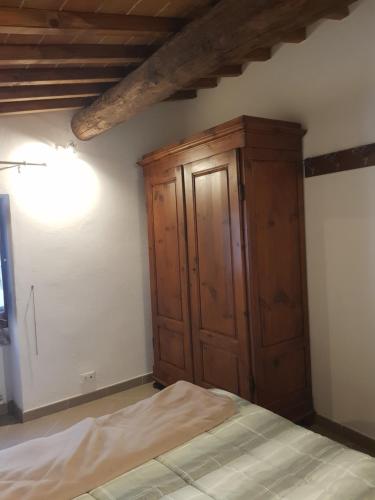 a bedroom with a wooden cabinet and a bed at Casa Marzia in Montevarchi