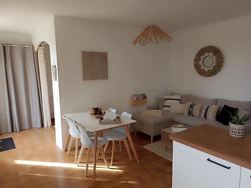 a kitchen and living room with a table and a couch at La petite maison à la campagne ! in Parcé-sur-Sarthe