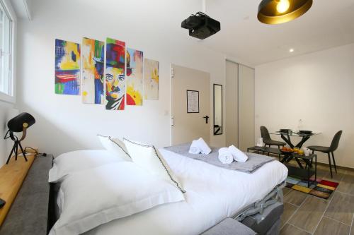 une chambre avec un lit blanc et une table dans l'établissement expat renting - L'Artiste - Netflix - Proche gare, à Toulouse