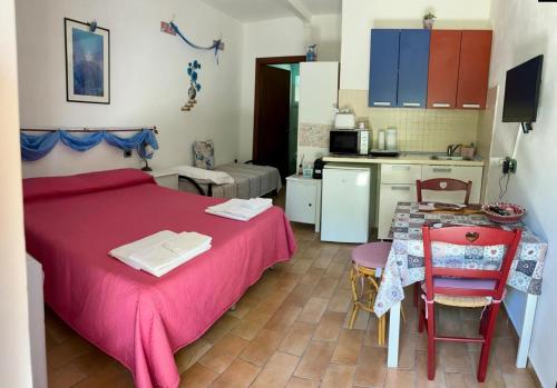 a bedroom with a bed and a table and a kitchen at Agriturismo Fattoria Del Colle By Enrico in Casa Cappanera