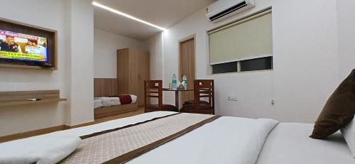 a bedroom with a bed and a flat screen tv at Metropolitan Inn IGI Airport New Delhi in New Delhi