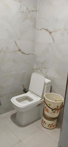 a bathroom with a toilet and a trash can at Metropolitan Inn IGI Airport New Delhi in New Delhi