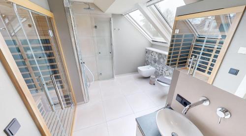 a bathroom with a sink and a shower and a toilet at Heaven House Penthousewohnung Sterngucker mit Whirlpool in Timmendorfer Strand
