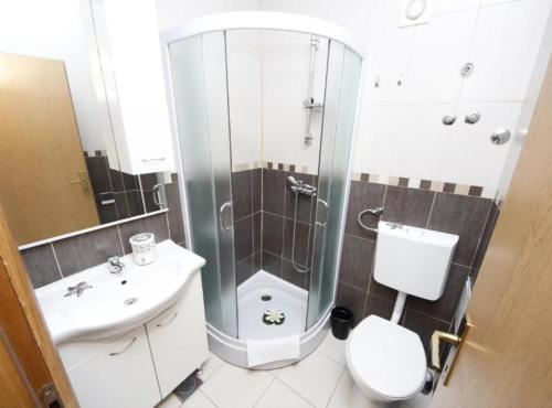 Un baño con ducha, inodoro y lavabo. en Apartments Katija, en Baška Voda