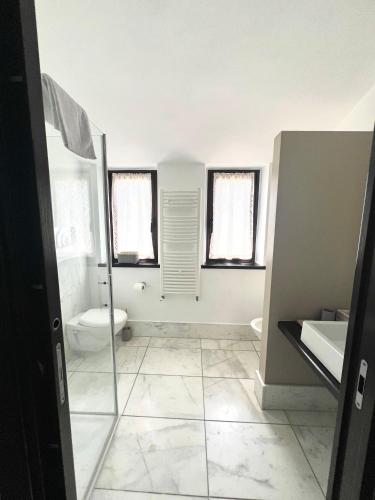 a bathroom with a shower and a toilet and windows at Terra del Gattopardo in Palma di Montechiaro