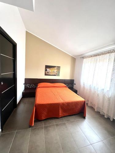 a bedroom with a bed with an orange comforter at Terra del Gattopardo in Palma di Montechiaro