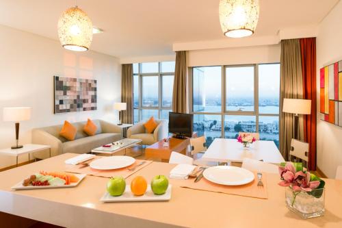 a living room with a large table with fruits on it at Ibis Abu Dhabi Gate in Abu Dhabi