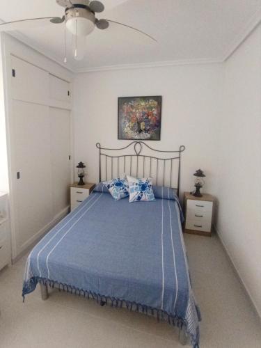 a bedroom with a bed with a blue comforter at Dune Beach in Arenales del Sol
