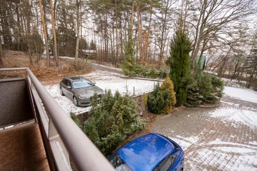 a car parked on a snow covered road with trees at Chata Guľka Kováčová in Kováčová