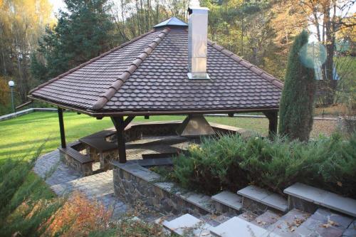 a gazebo with a shingled roof in a garden at Chata Guľka Kováčová in Kováčová