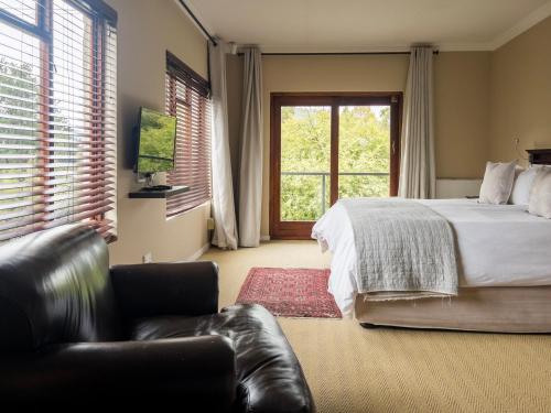 a bedroom with a bed and a couch and a window at 727 Church in Clarens