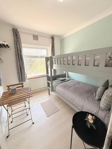 a bedroom with a bunk bed and a table at Wembley Rooms in London