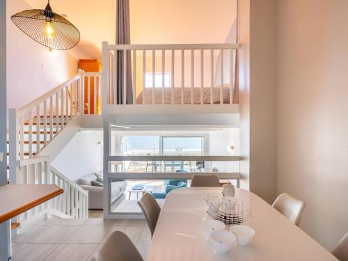 une salle à manger avec une table et des chaises et un escalier dans l'établissement Carnac - Triplex 2 pièces + mezzanine, 85m², 1 chambre, Parking, Proche plage - FR-1-477-84, à Carnac