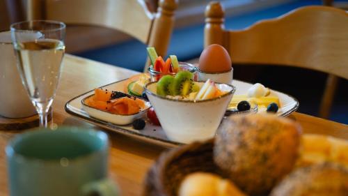a tray of food on a table with a plate of fruit at Gästehaus am Fürstweg in Heuchelheim-Klingen