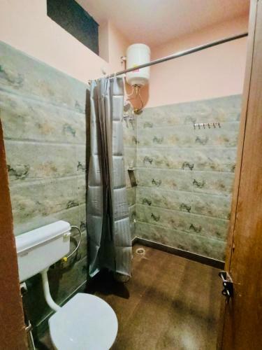 a bathroom with a toilet and a shower at A Cozy Villa In Rishikesh-The Figtree Inn in Rishīkesh