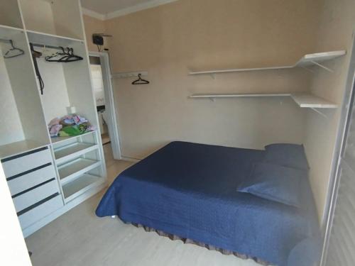 a small bedroom with a blue bed and a closet at Apartamento completo 2 quartos a 3km basílica in Aparecida