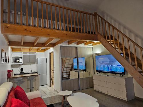 un salon avec un escalier et une cuisine dans l'établissement Le Louvre, à Saint-Symphorien-dʼOzon