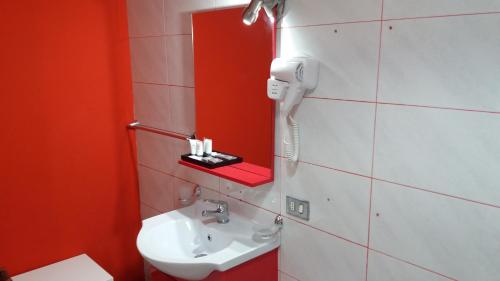 bagno con lavandino e telefono appeso al muro di Studio Notte a Telese