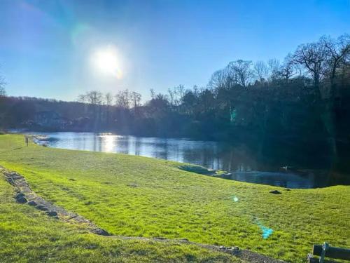 ナレスボロにあるBordeuax Holiday home by the river Nidd N24の川沿いの太陽が輝く草原