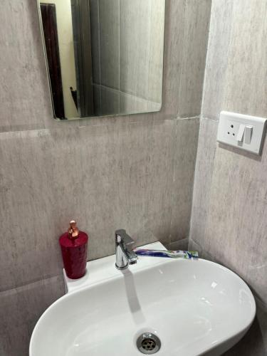 a bathroom sink with a mirror and a red candle at Hotel Fun Suite- Baner Hill in Pune