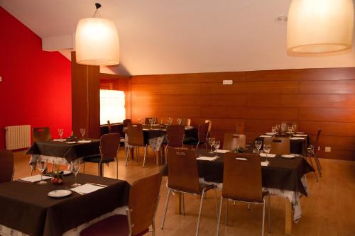a dining room with tables and chairs with black tablecloths at Hotel SNÖ La Corza Blanca in Brañavieja