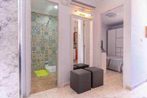 a room with a bathroom with a bed and a stool at Beproud Gc in Maspalomas
