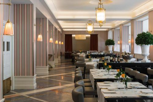 un ristorante con tavoli, sedie e lampadari di Starhotels Michelangelo Rome a Roma