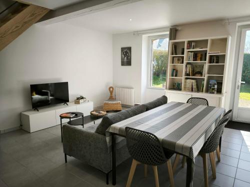 - un salon avec une table, un canapé et une télévision dans l'établissement Stagadenn, à Camors