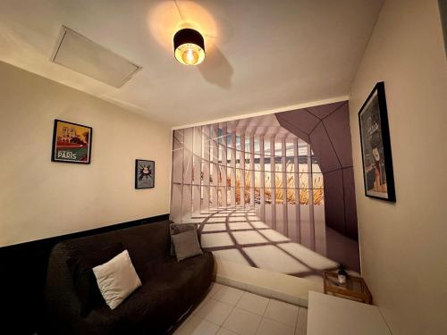 un salon avec un canapé et un tableau au mur dans l'établissement STUDIO PARIS Gare de Lyon, à Paris