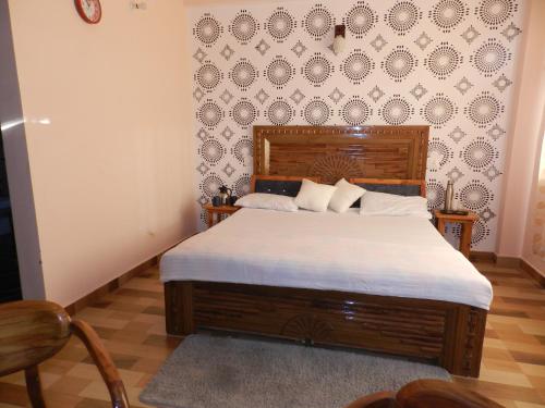 a bedroom with a bed and a wall at The Banoak Homes Mashobra in Shimla