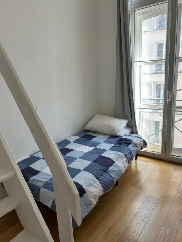 - un petit lit dans une chambre avec un escalier dans l'établissement Loft Le Marais à Place des Vosges, à Paris
