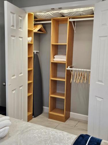 a bedroom with a closet with wooden shelves at Cozy Norment Forest Apartment in Lumberton