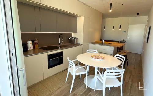 a kitchen with a table and chairs in a kitchen at HT - Luxury apartment at Palm Beach Jesolo in Lido di Jesolo