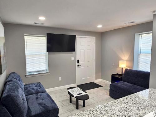 a living room with a couch and a flat screen tv at Cozy Norment Forest Apartment in Lumberton
