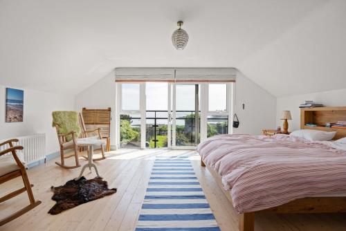 a bedroom with a large bed and a large window at Large Stunning Sea View Coastal Townhouse in Killough