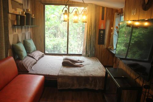 a small bed in a room with a window at Do Dee cafe in Bangkok