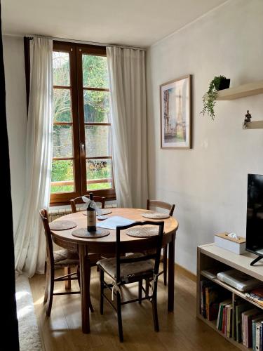 Un comedor con mesa y sillas y una ventana. en Dove Nest, en Figeac